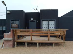 two wooden benches sitting in front of a black building at Cabañas Mediterraneas in Pichidangui