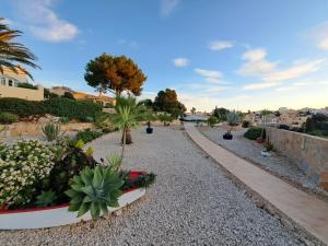 a garden with cacti and plants on a gravel road at la ventana al mar in Jávea