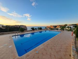a swimming pool with the ocean in the background at la ventana al mar in Jávea
