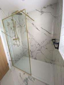 a bathroom with a glass shower with a cross on the wall at The Annex, Bath Road, Saltford in Saltford