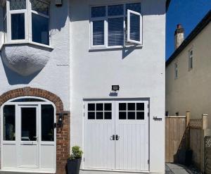 een wit huis met een witte deur en ramen bij The Annex, Bath Road, Saltford in Saltford