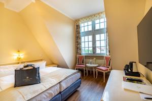 a hotel room with a bed and a table at Seehotel Schloss Klink in Klink