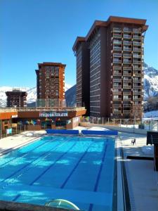 a swimming pool in front of a hotel at Studio Zodiaque in Le Corbier