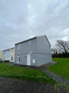 a large gray house with a white garage at Chy Lowen - Atlantic Reach in Newquay