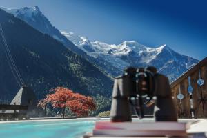eine Kamera auf einem Buch vor einem Berg in der Unterkunft Park Hotel Suisse & Spa in Chamonix-Mont-Blanc