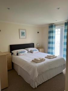 a bedroom with a large bed with towels on it at Chy Lowen - Atlantic Reach in Newquay