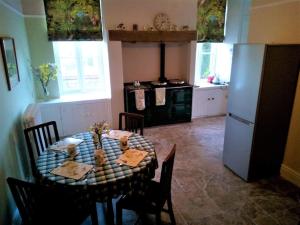 a kitchen with a dining table and a refrigerator at Tranquil getaway on edge of the Brecon Beacons in Llandovery