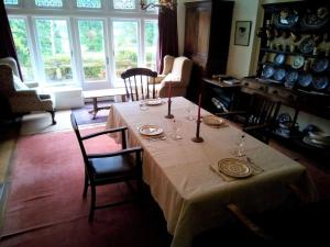 une salle à manger avec une table, des assiettes et des verres à vin dans l'établissement Tranquil getaway on edge of the Brecon Beacons, à Llandovery