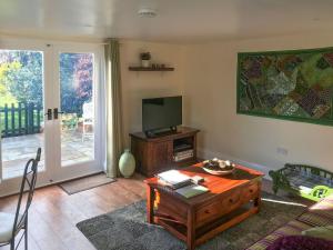 a living room with a coffee table and a tv at Tiptoe in Steeple Ashton