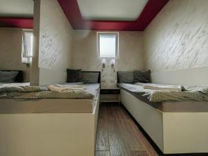 a room with two beds in a room at OldBrick PUB in Sombor