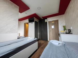 two beds in a room with red ceilings at OldBrick PUB in Sombor
