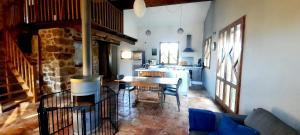 Il comprend un salon avec une table et une cuisine. dans l'établissement Maison familiale chaleureuse idéalement située, à Silhac