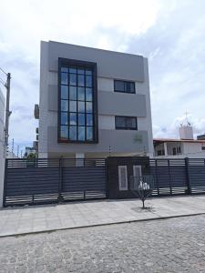 un edificio con una valla delante en FLAT - 200m da orla do Bessa, en João Pessoa