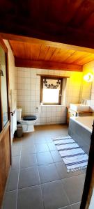 La salle de bains est pourvue de toilettes, d'un lavabo et d'une fenêtre. dans l'établissement Maison familiale chaleureuse idéalement située, à Silhac