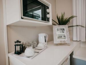 eine Küchentheke mit Mikrowelle und Teezubehör in der Unterkunft Sylvern Bed and Breakfast in Durban
