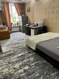 ein Hotelzimmer mit einem Bett und einem Schreibtisch mit einem Computer in der Unterkunft Center in the center in Chişinău