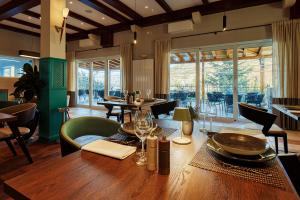 Veladrion Adults Exclusive Boutique Resort في سينج: غرفة طعام مع طاولة وكراسي وغرفة مع نوافذ