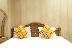 two yellow pillows with arrows on them on a bed at Hotel Classic in Lucknow
