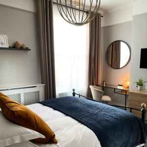 una camera da letto con un letto con specchio e una sedia di Franklin Mount Boutique Guesthouse a Harrogate