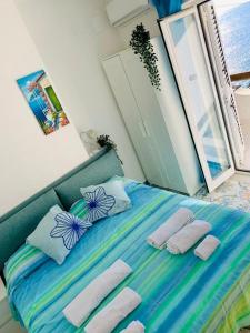 un letto con due cuscini e asciugamani di Casa Bianca A S'Angelo a Ischia