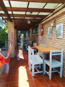 patio con mesa, sillas y pared de ladrillo en BUNGALOWS JAUREGUIBEACH, en Jaureguiberry
