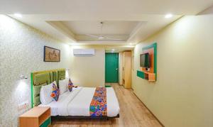 um quarto com uma cama grande e uma televisão em FabHotel Aerosky Grand em Nova Deli