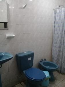 a bathroom with a blue toilet and a sink at Alojamiento Portal Salta in Salta