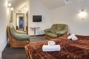 ein Hotelzimmer mit einem Bett und zwei Stühlen in der Unterkunft Świtezianka in Rymanów-Zdrój