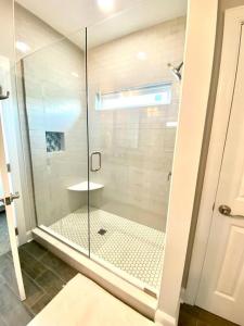 a shower with a glass door in a bathroom at Henderson Haven 4 BR / 3 BA Villa, Steps to Beach in Wrightsville Beach