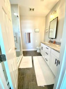 a bathroom with a toilet and a sink and a mirror at Henderson Haven 4 BR / 3 BA Villa, Steps to Beach in Wrightsville Beach
