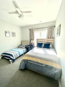 a bedroom with two beds and a ceiling fan at Henderson Haven 4 BR / 3 BA Villa, Steps to Beach in Wrightsville Beach