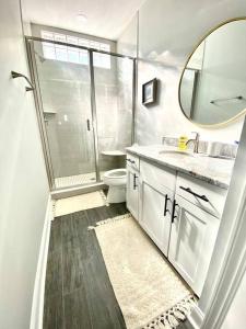 a bathroom with a toilet and a sink and a mirror at Henderson Haven 4 BR / 3 BA Villa, Steps to Beach in Wrightsville Beach