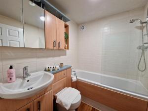a bathroom with a sink and a toilet and a tub at Stylish Luxury Serviced Apartment next to City Centre with Free Parking - Contractors & Relocators in Coventry +13 photos