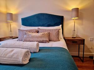 a bedroom with a large bed with a blue headboard at Stylish Luxury Serviced Apartment next to City Centre with Free Parking - Contractors & Relocators in Coventry