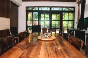 un grande tavolo in legno in una stanza con finestre di Villa Mihajlovo a Kavadarci