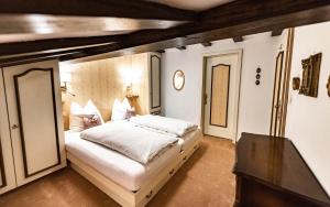 レッヒにあるHotel Olympiaのベッドルーム(大きな白いベッド1台、テーブル付)