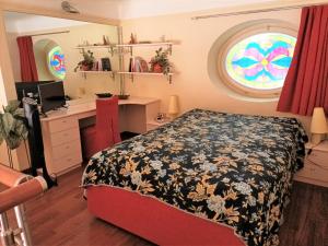 een slaapkamer met een bed, een bureau en een raam bij Casa Alexandra in centro e a pochi passi dal mare in Imperia +10 foto's