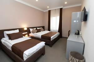 Cette chambre comprend deux lits et une télévision. dans l'établissement Aragats Hotel, à Aragats