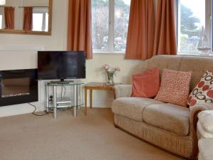 a living room with a couch and a flat screen tv at Bayview in Overcombe