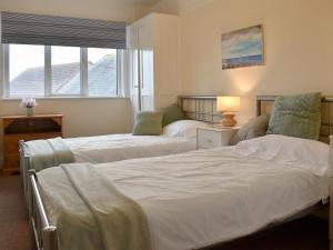 a bedroom with two beds and a window at Bayview in Overcombe