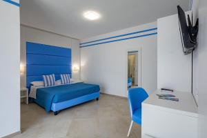 a bedroom with a blue bed and a blue chair at Brezza Marina in Lampedusa
