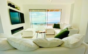 a living room with a white couch and a large window at Villa Olimpo in Avola
