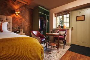 a bedroom with a bed and a table and chairs at The Masons Arms in Branscombe