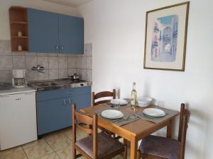 a kitchen with a wooden table with chairs and a dining room at Apartments Kesic in Barbat na Rabu