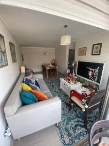 sala de estar con sofá y TV en Habitación con baño privado en departamento, en Arica