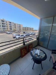 balcón con mesa y vistas a un aparcamiento en Habitación con baño privado en departamento, en Arica