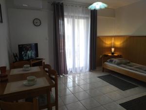 Zimmer mit einem Bett, einem Tisch und einem Fenster in der Unterkunft Apartments Kesic in Barbat na Rabu