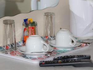 estante de cristal con dos tazas y mando a distancia en Gaediwe Guesthouse, en Pudumong