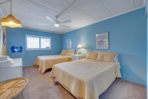 - une chambre avec 2 lits et un mur bleu dans l'établissement Salty Sands, à Ocean City