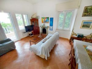 ein Wohnzimmer mit einem Bett und einem TV in der Unterkunft Un letto a Gaeta - Villa a Fontania in Gaeta